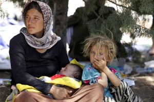 A displaced family from the minority Yazidi sect, fleeing the violence in the Iraqi town of Sinjar, waits for food while resting at the Iraqi-Syrian border crossing in Fishkhabour, Dohuk province August 13, 2014. REUTERS/Youssef Boudlal (IRAQ - Tags: CIVIL UNREST POLITICS) - RTR42BTM
